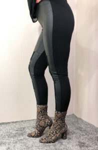 Desk with leather desk pad, walnut desk organizer, wireless keyboard and mouse, and porcelain mug.