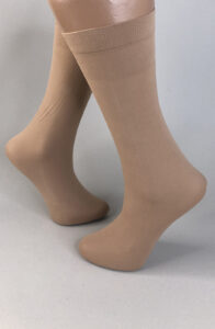 Desk with leather desk pad, walnut desk organizer, wireless keyboard and mouse, and porcelain mug.