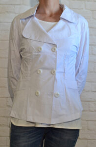 Desk with leather desk pad, walnut desk organizer, wireless keyboard and mouse, and porcelain mug.