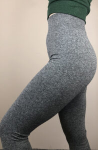 Desk with leather desk pad, walnut desk organizer, wireless keyboard and mouse, and porcelain mug.