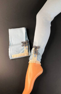 Desk with leather desk pad, walnut desk organizer, wireless keyboard and mouse, and porcelain mug.