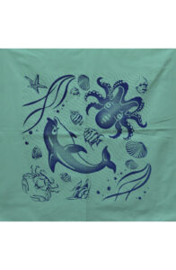 Desk with leather desk pad, walnut desk organizer, wireless keyboard and mouse, and porcelain mug.